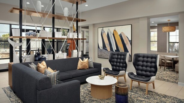 A modern living room with a sofa, chairs, a coffee table, and a hanging light fixture. - Residence Inn by Marriott San Diego Oceanside (Oceanside)