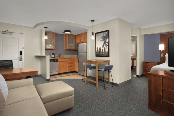 A compact hotel room with a kitchenette, a dining area, a sofa, and a bed. - Residence Inn by Marriott San Diego Oceanside (Oceanside)
