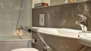 A modern bathroom with a bathtub, toilet, and sink.