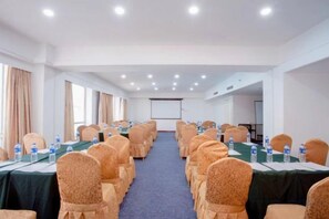 A conference room with rows of tables, chairs, and a projector screen. - Shenyang Tianbao International Hotel (Zhongjie) (Shenyang)