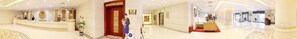 Un hall d’hôtel comprenant un comptoir d’accueil, une porte rouge et un espace salon avec une table basse.