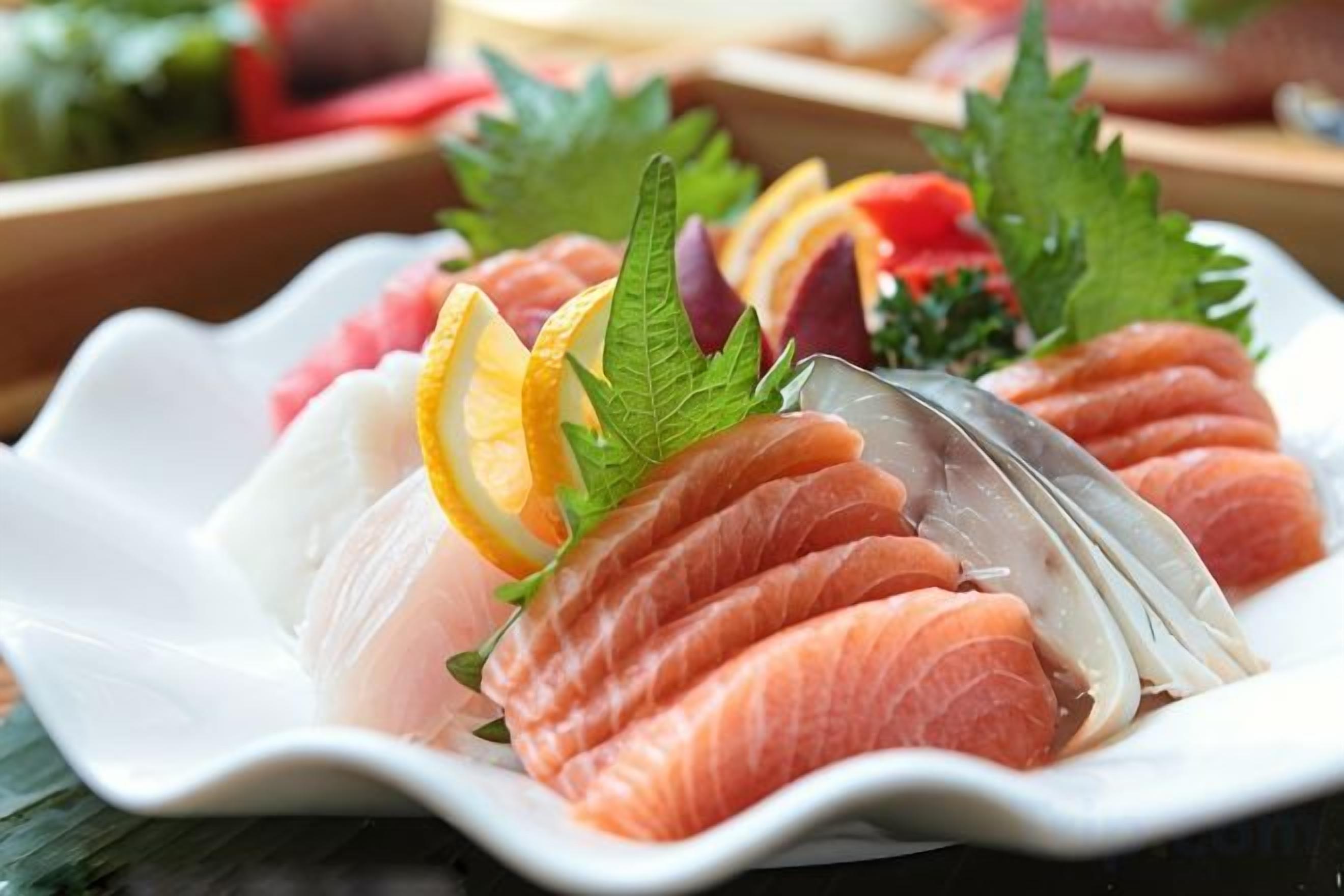 A plate of sushi with various types of fish and garnishes.