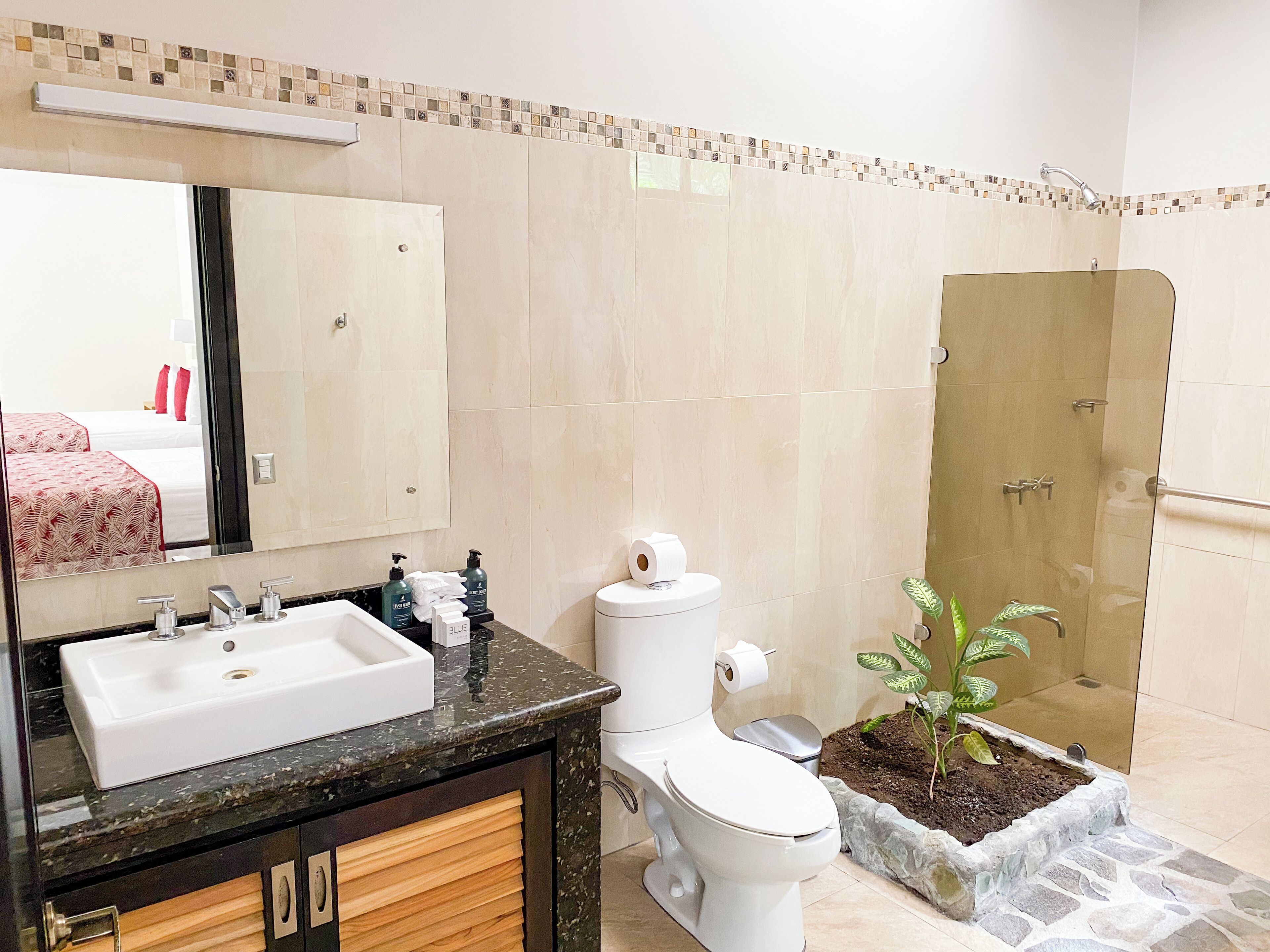 Un baño con lavamanos, inodoro y ducha.