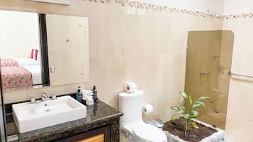 Un baño con lavamanos, inodoro y ducha.