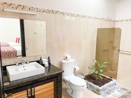 Un baño con lavamanos, inodoro y ducha.