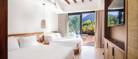A hotel room with two beds, a ceiling fan, a large window with a view of greenery, and a TV on a wooden cabinet.