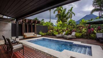 Relax by the serene pool surrounded by lush tropical plants and a majestic mountain view.