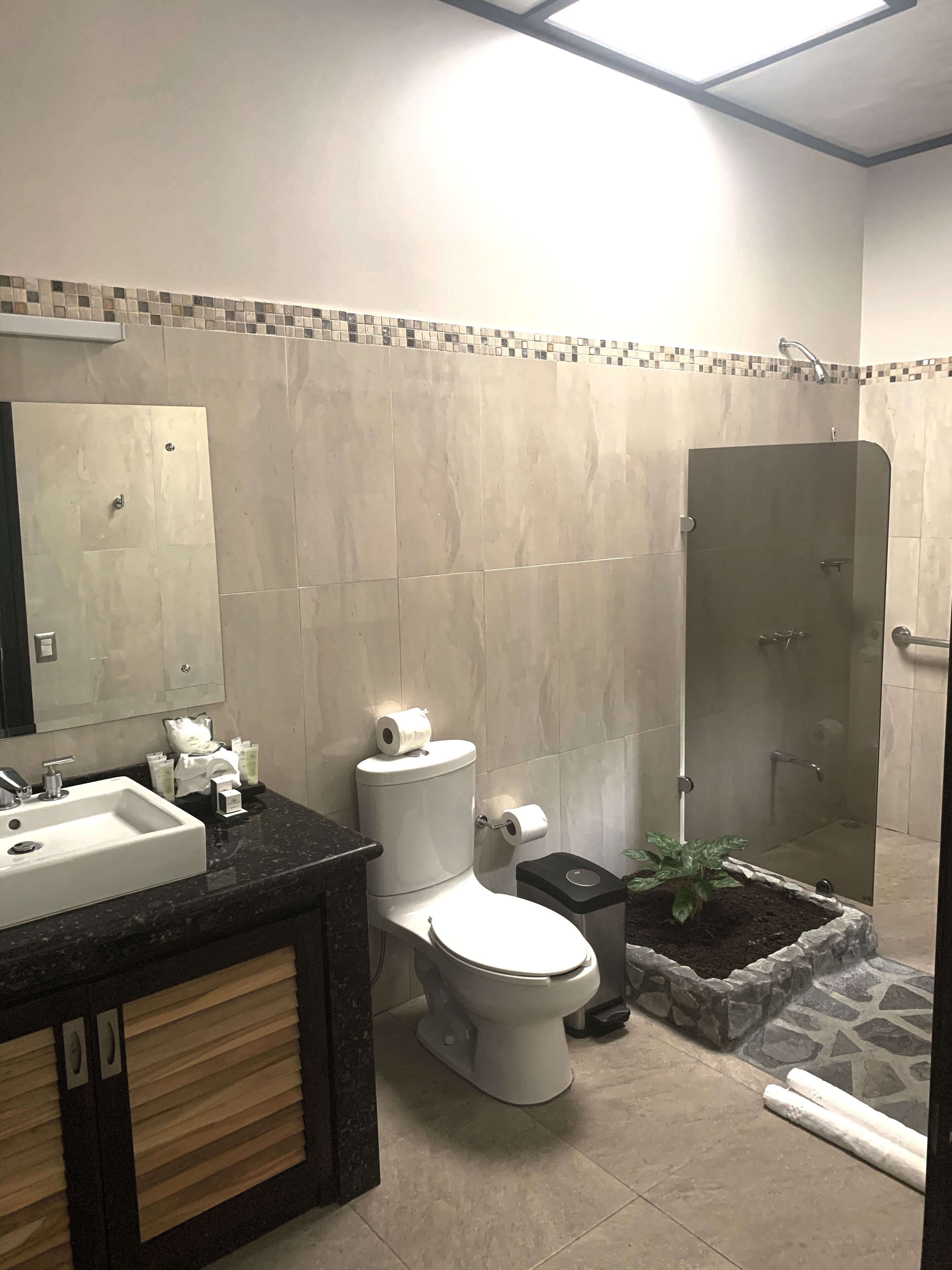 Un baño moderno con lavamanos, inodoro y zona de ducha.
