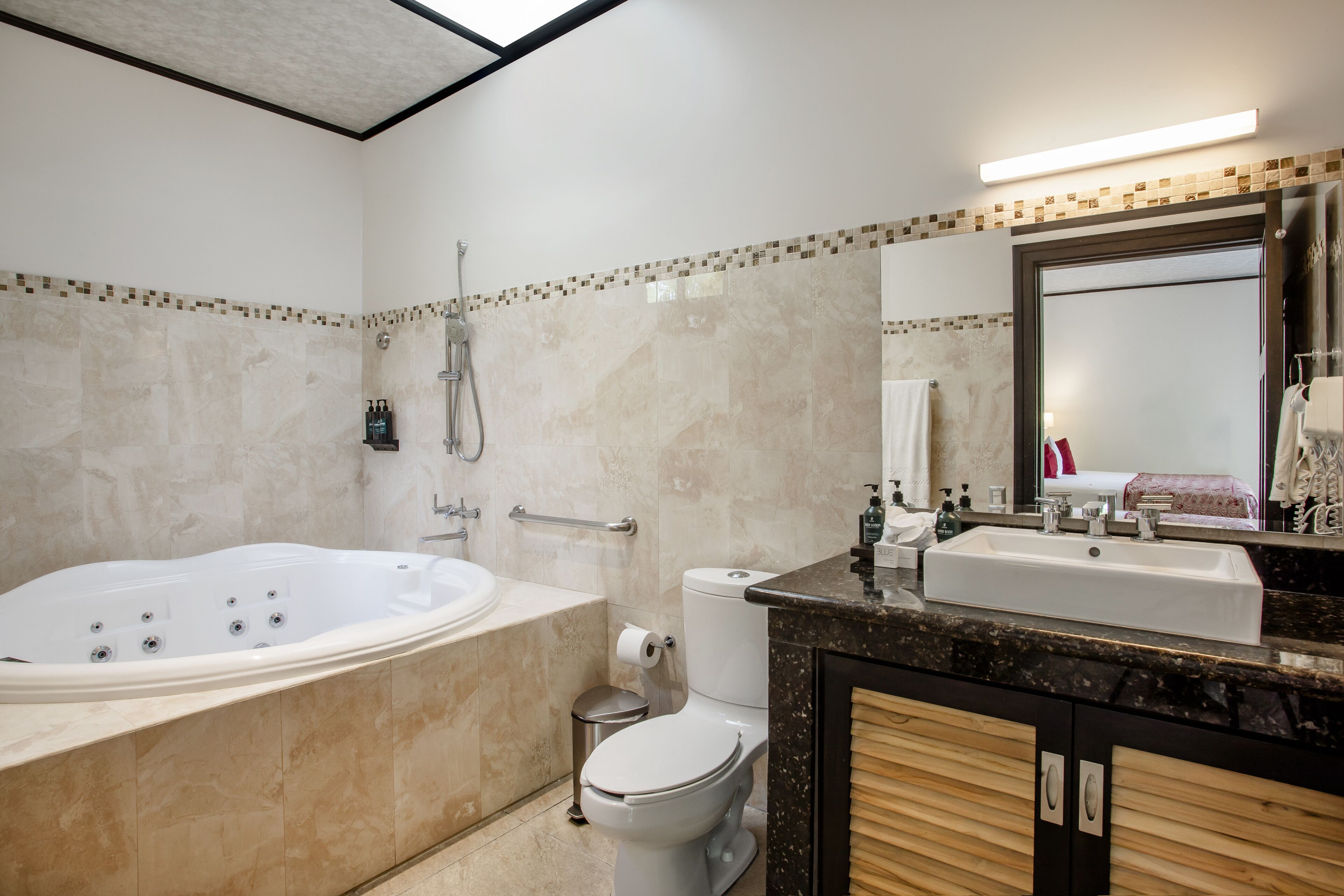 A modern bathroom with a large bathtub, a toilet, and a sink.