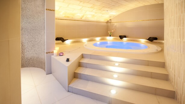 A modern spa area with a hot tub, steps leading to it, and a tiled floor. - Hôtel de Sèze (Bordeaux)