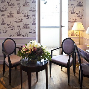 A room with two chairs, a table with a floral arrangement, and a lamp. - Hôtel de Sèze (Bordeaux)