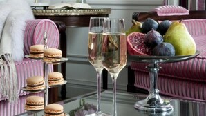 A room with a glass table displaying macarons, a glass of champagne, and a fruit arrangement. - Hôtel de Sèze (Bordeaux)