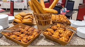 Une table de buffet proposant une variété de pains et de viennoiseries.