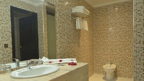 Une salle de bain avec un lavabo en marbre, un bidet et un miroir.