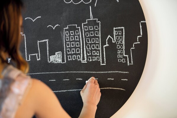 Une personne qui dessine un paysage urbain sur un tableau noir.