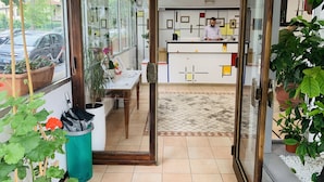 Zona de recepción con un mostrador, sillas y un ventanal con vista a un estacionamiento.
