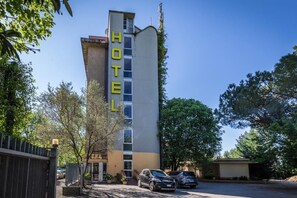 A hotel with a tall, vertical sign reading 'HOTEL' and a modern building facade. - Real (Florence)