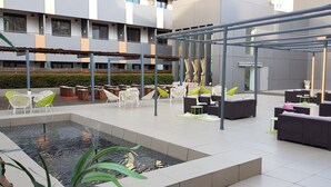 A rooftop terrace with outdoor seating, a water feature, and a pergola structure. - Hotel Vincci Zentro Zaragoza (Zaragoza)