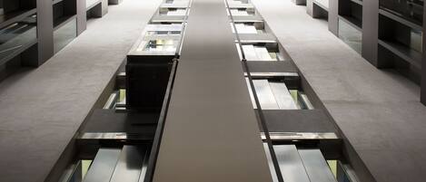 A modern library interior with rows of bookshelves and a central walkway.