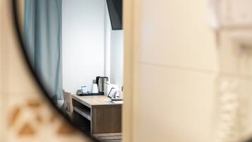 Eine moderne Küche mit Holztischplatte, einem Wasserkocher und einer Kaffeemaschine.
