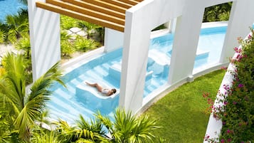Un espace piscine moderne où une personne se détend sur une chaise longue.