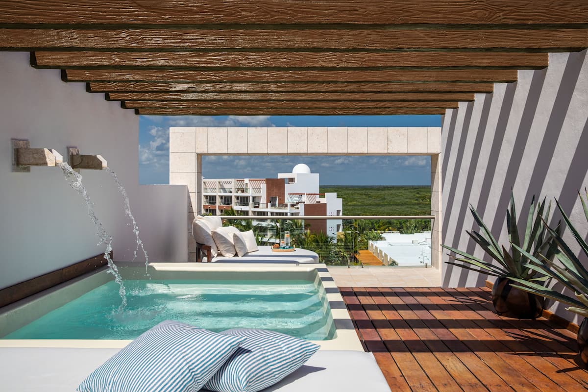 A rooftop pool area with a view of buildings and a clear sky.