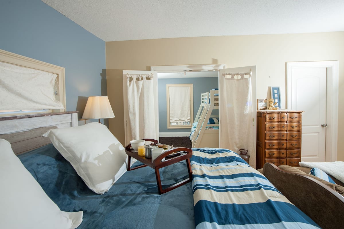 A hotel room with a bed, bedside table, and a dresser.
