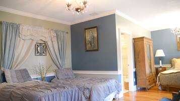 Una camera da letto con due letti, un lampadario, una cassettiera e uno specchio.