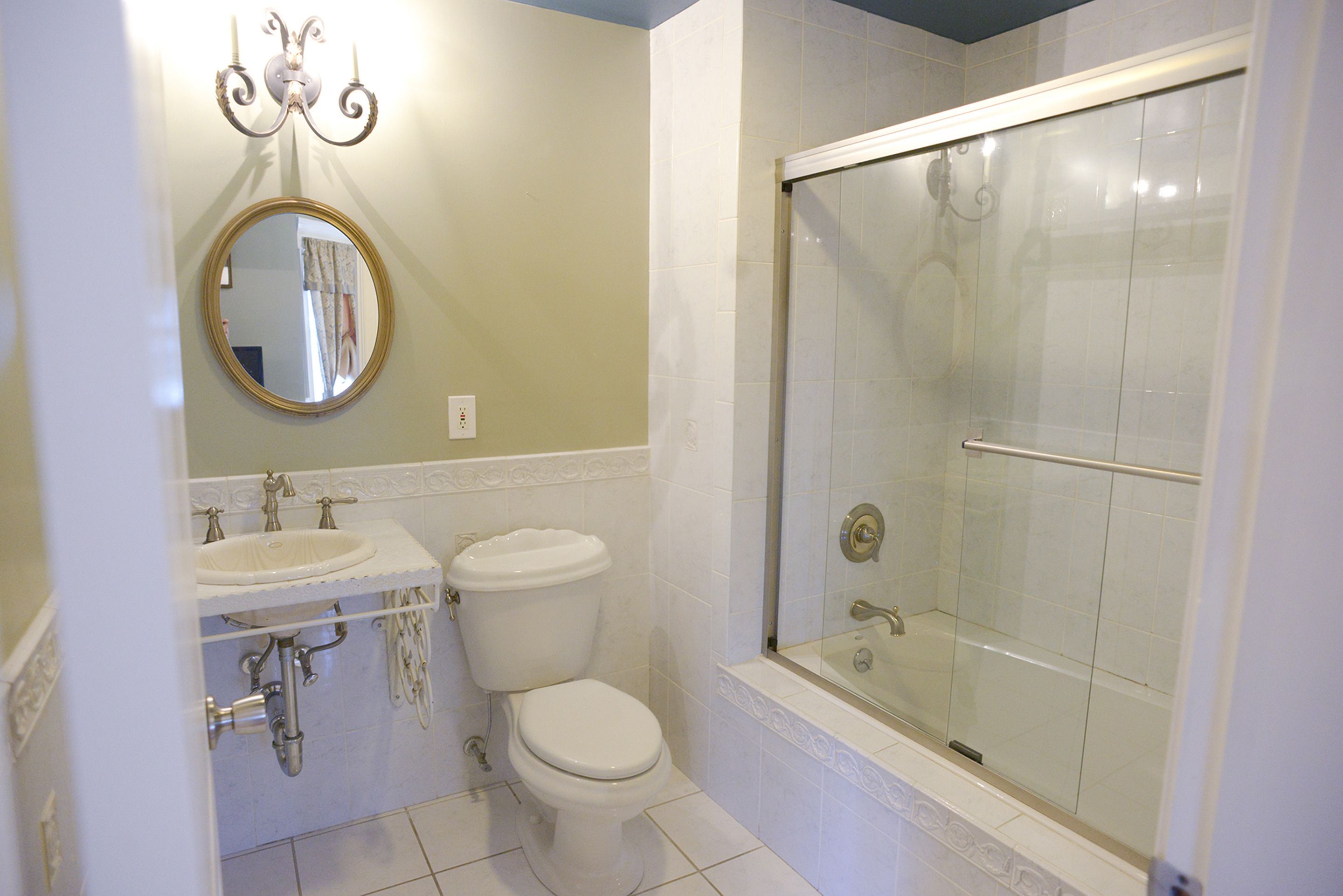 A bathroom with a sink, toilet, and glass-enclosed shower.