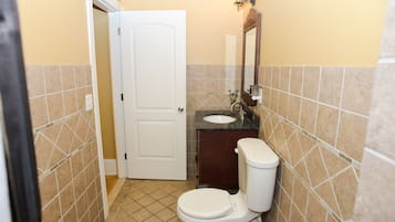 A small bathroom with a toilet, sink, and mirror.