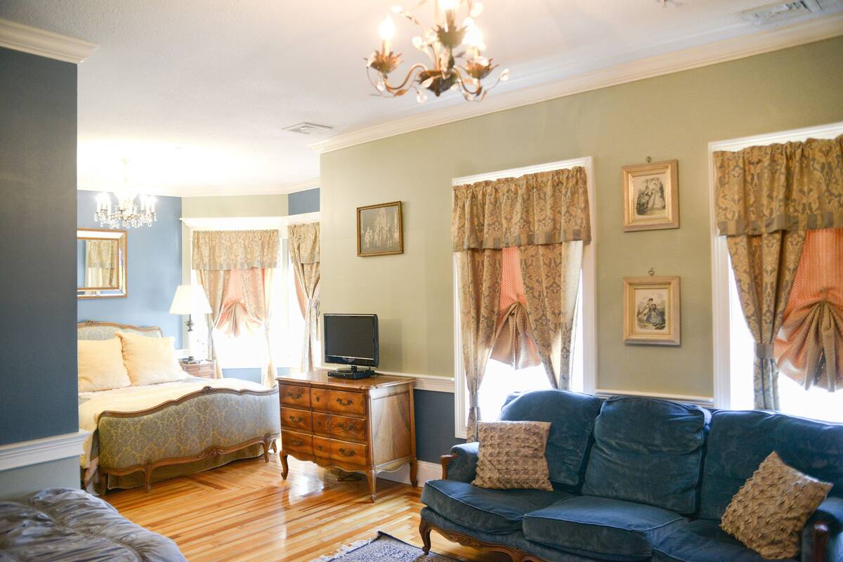 A bedroom with a bed, dresser, and television.