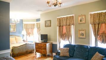 A bedroom with a bed, dresser, and television.