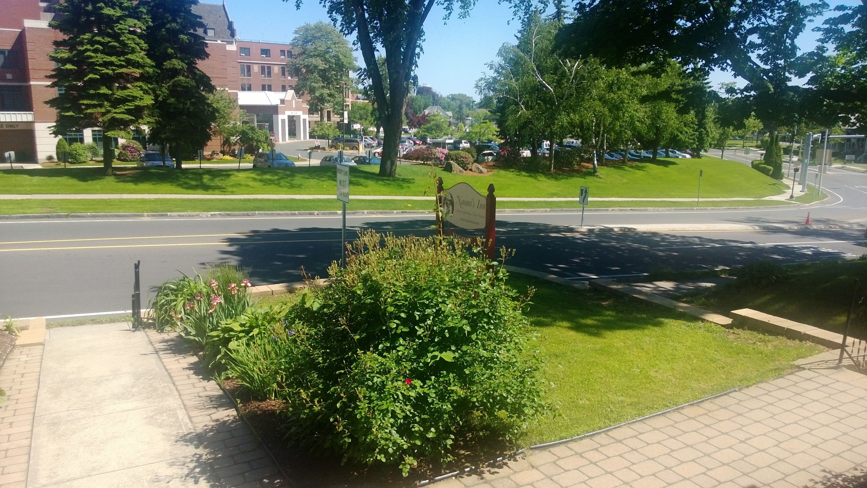 Schild für 'Kavlin's Inn' mit freiem Blick auf die umliegende Grünfläche und einer Straße im Hintergrund.