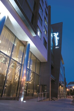 A modern building with large glass windows and a prominent vertical light feature. - Radisson Blu Royal Hotel, Dublin (Dublin)
