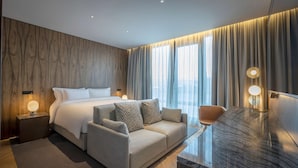 A modern hotel room with a large bed, a sofa, a desk, and a view of the city. - Radisson Blu Royal Hotel, Dublin (Dublin)