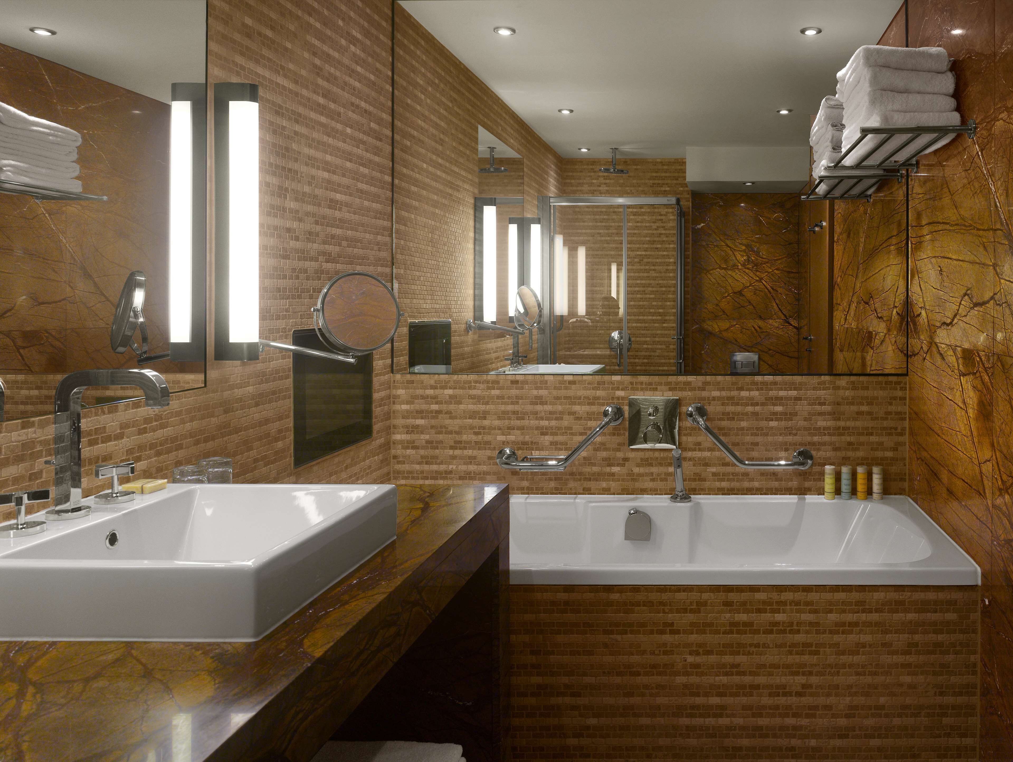 Uma casa de banho moderna com duas pias, um espelho grande e um porta-toalhas.