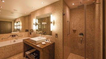 A modern bathroom with a large mirror, a sink, and a shower area.