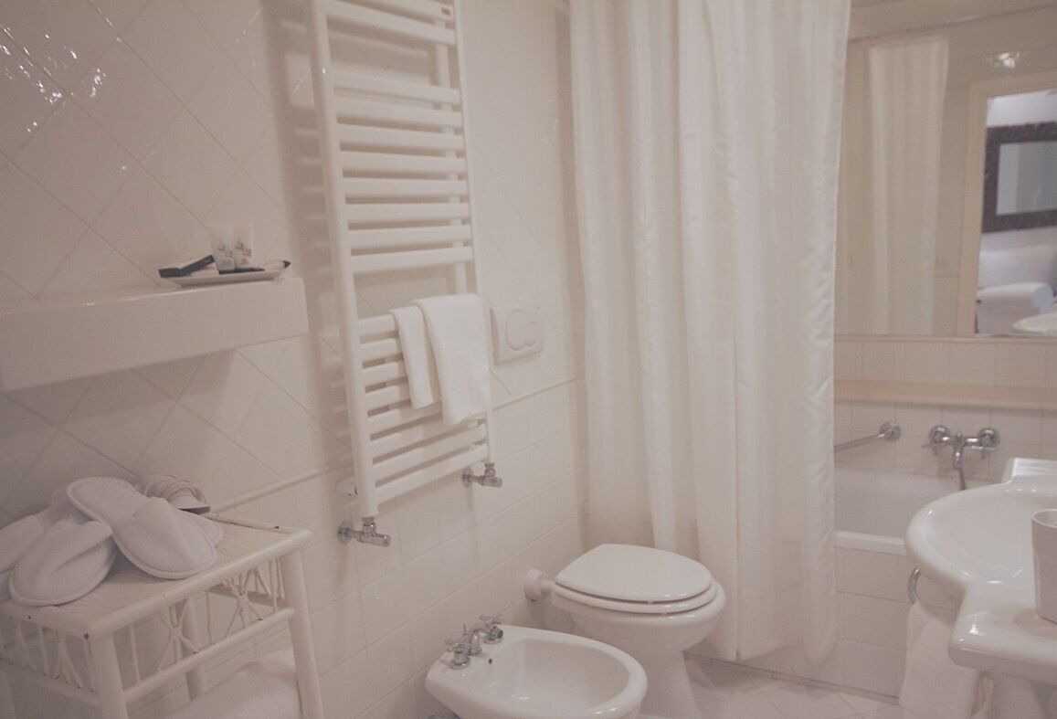 A bathroom with a toilet, bidet, and bathtub.