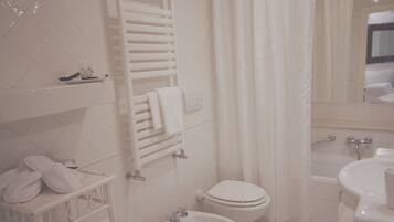 A bathroom with a toilet, bidet, and bathtub.