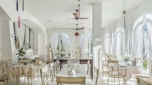 A spacious dining area with high ceilings, large windows, and elegant chandeliers. - Il San Francesco Charming Hotel (Sabaudia)