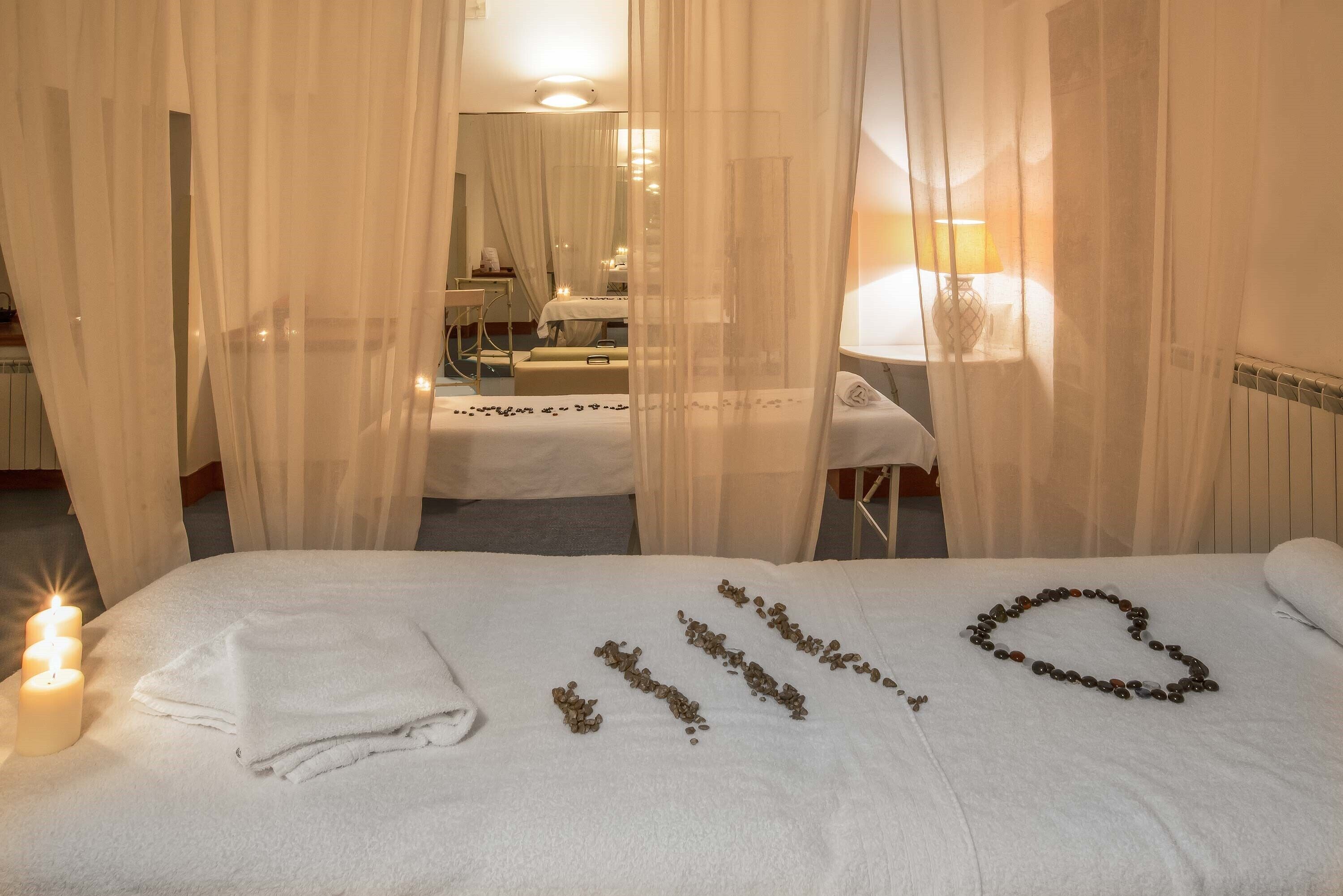 A hotel room with a bed, a bedside table, a lamp, and a mirror.