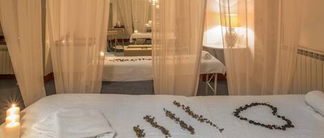 A hotel room with a bed, a bedside table, a lamp, and a mirror.