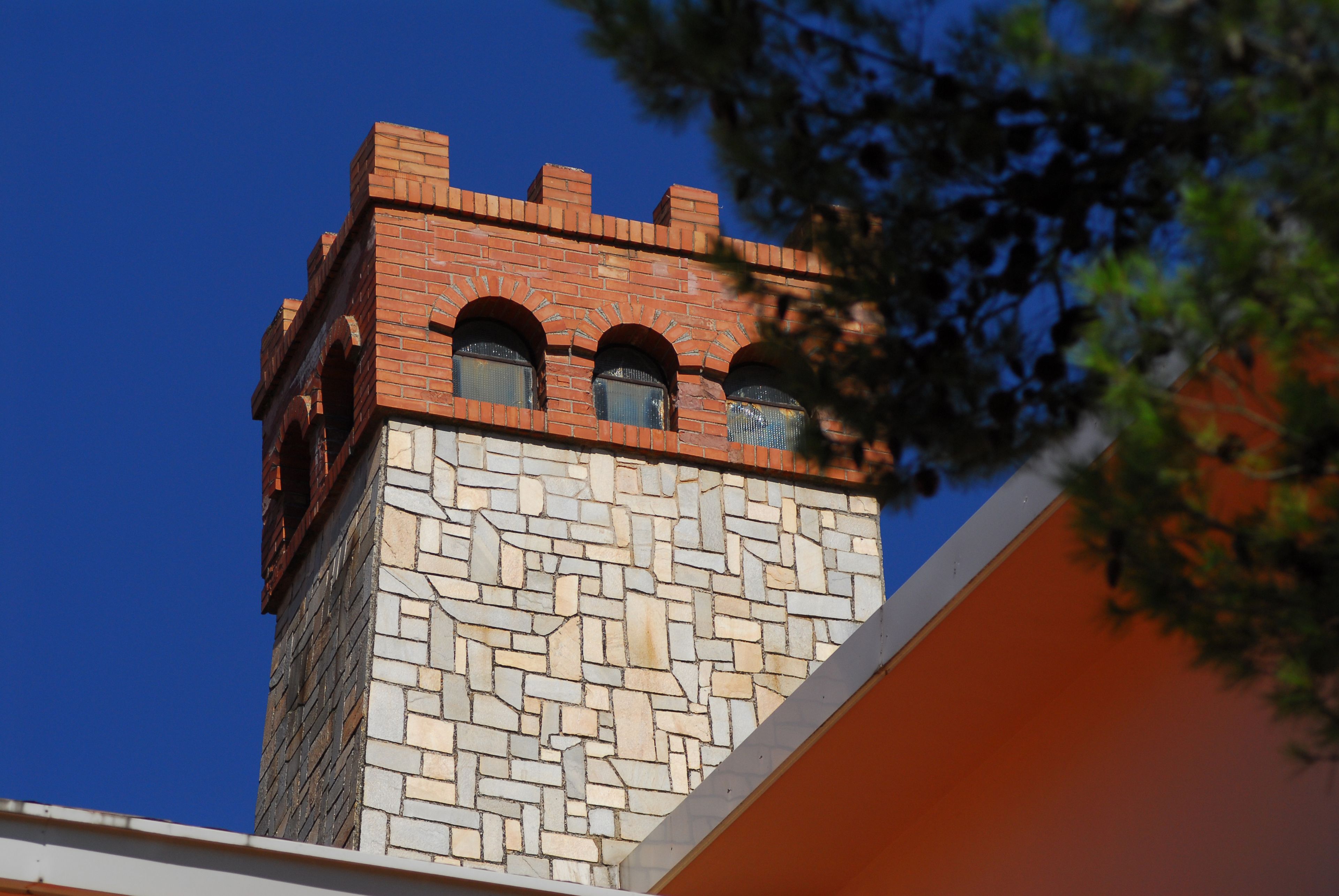 A tower with a brick upper section and a lower stone section.