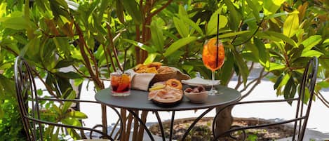 Una mesa al aire libre con diversos alimentos, una bebida y un vaso con una rodaja de limón.