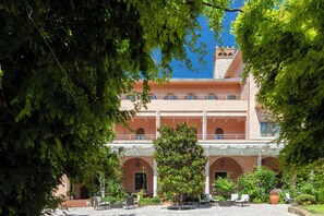 A building with a courtyard, outdoor seating, and a clear blue sky. - Park Hotel San Michele (Martina Franca)