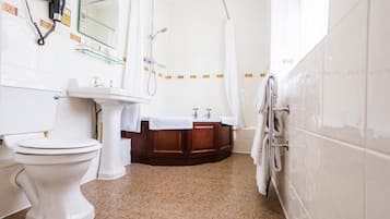 A bathroom with a toilet, sink, and shower.
