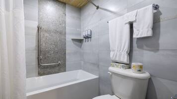 A bathroom with a bathtub, toilet, and a shower area.
