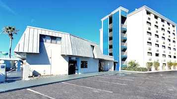 A hotel with a modern design, featuring a parking lot and a building with multiple floors.