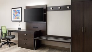 A modern office space with a desk, chair, TV, and wardrobe.