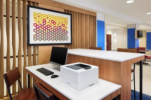 A modern office space with a desk, computer, printer, and a framed artwork on the wall. - Holiday Inn Express & Suites Seymour by IHG (Seymour)